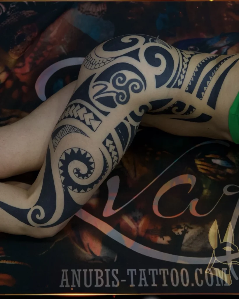 Velika tribal tattoo kompozicija koja prati anatomiju noge